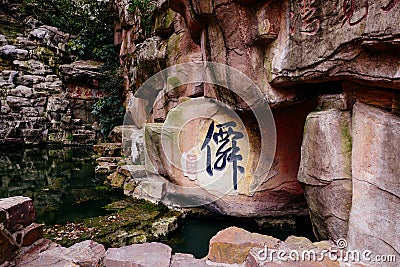 Stone Buddha on the stone wall at Wuxi Yuantouzhu - Taihu scenery garden, China. Editorial Stock Photo