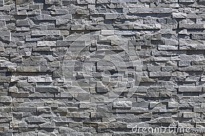 Stone coating wall made of striped stacked bricks of natural gray rocks. External wall covering Stock Photo