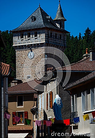 Stone cross and Flowers ,in the medieval town of Malzieu , lozere France .a stage in the way of compostelle a long distance walk Stock Photo