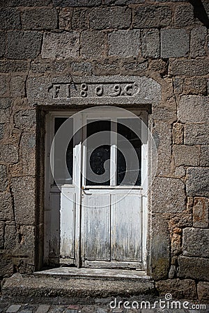 Stone cross and Flowers ,in the medieval town of Malzieu , lozere France .a stage in the way of compostelle a long distance walk Stock Photo