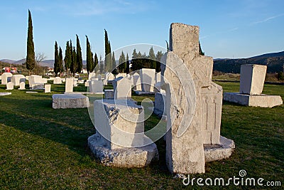 Stone cross and tombstones of medieval necropolis Radimlja Stock Photo