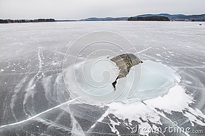 A stone is dramatically breaking the ice, literally Stock Photo