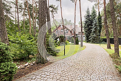 Stone driveway to english red brick residence in the forest Stock Photo