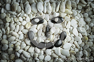 Stone faces small black and white stones with sad happy and angry faces Stock Photo