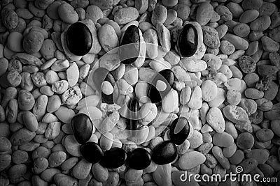 Stone faces small black and white stones with sad happy and angry faces Stock Photo