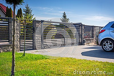 Stone fence and entrance gate with remote control Stock Photo