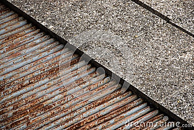 Stone floor with shaft detail with iron and rusted grates outside Stock Photo