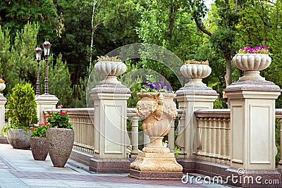 Stone flowerpots with flowers on pedestals. Stock Photo