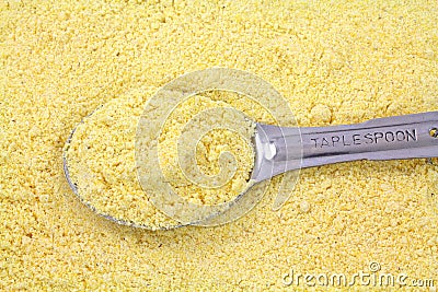 Stone ground yellow corn meal with tablespoon Stock Photo