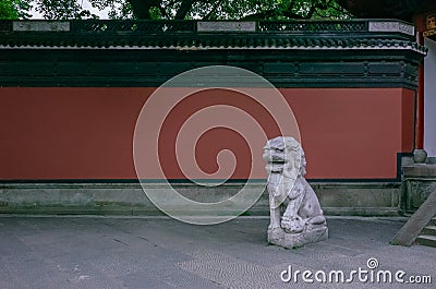 Stone lion and red wall near entrance of Yue Fei Temple, near West Lake, in Hangzhou, China Stock Photo