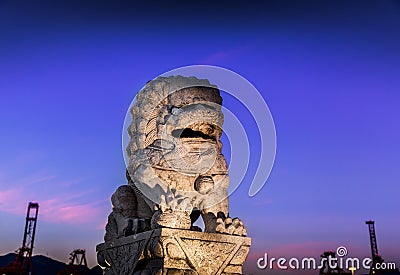 Stone lion statue near the port of Vancouver at sunset. Stock Photo