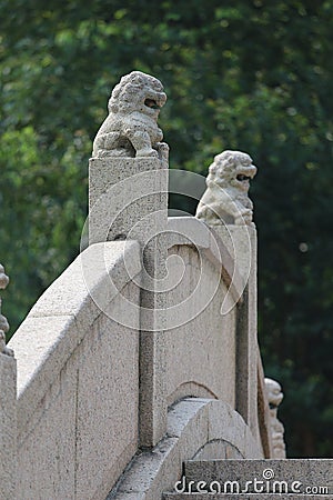 Stone lions on a bridge in a garden Stock Photo