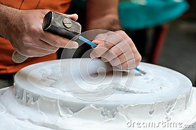 Stone mason at work carving an ornamental relief Stock Photo