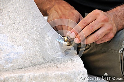 Stone mason at work carving an ornamental relief Stock Photo