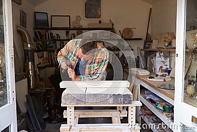 Stone Mason At Work On Carving In Studio Stock Photo