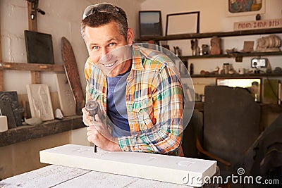 Stone Mason At Work On Carving In Studio Stock Photo