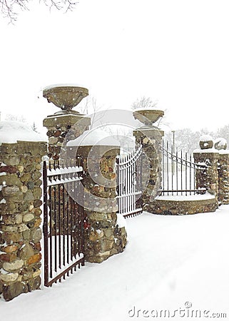 Stone & Metal Bared Fence in the Winter Snow Stock Photo