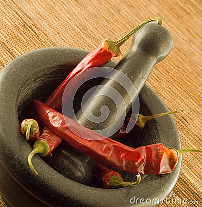 Stone mortar with red chillies Stock Photo