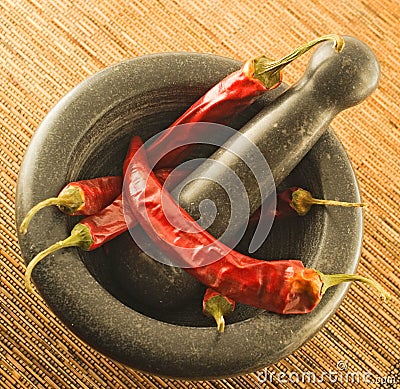 Stone mortar with red chillies Stock Photo