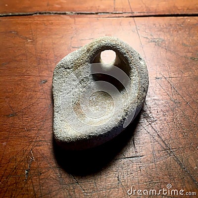 Stone with natural hole on antique wood table. Stock Photo