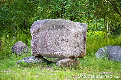 Stone parallelepiped on an improvised pedestal Stock Photo