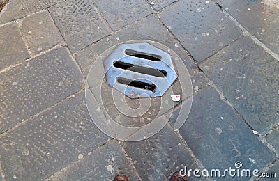 Metal drain in a medieval street Stock Photo