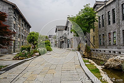 Stone-paved path in tile-roofed buildings in cloudy spring after Editorial Stock Photo