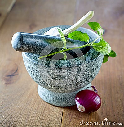 Stone pestle and mortar with mint and garlic Stock Photo