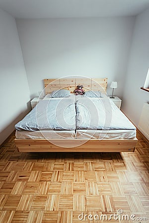 Stone pine bed: Empty wooden bed with pillow and blanket Stock Photo