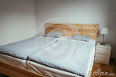 Stone pine bed: Empty wooden bed with pillow and blanket Stock Photo