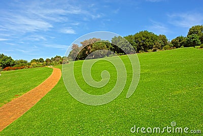 Stone road running through green meadow Stock Photo