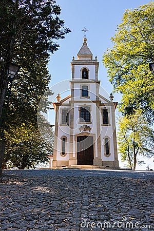 Stone road to church in park. Ancient white church with cross with trees and street lamp. Religion and faith concept. Stock Photo