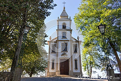 Stone road to church in park. Ancient white church with cross with trees and street lamp. Religion and faith concept. Stock Photo