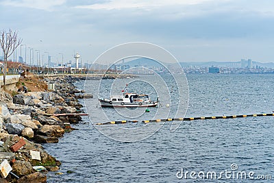 Stone shore, ship, seagulls flying over the sea Stock Photo