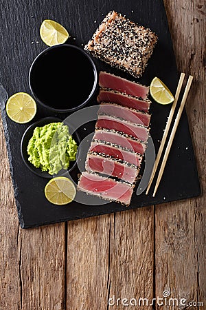 Stone slate tray with sliced tuna steak fried in sesame seeds. T Stock Photo