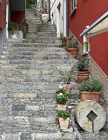 Stone stairway leading upward and lined with plants and flower pots in Varenna on Lake Como. Stock Photo