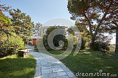 Stone tiled path and villa with garden in a sunny summer day Stock Photo