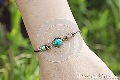 Stone tyrkys pendant bead bracelet on female wrist Stock Photo