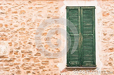 Stone wall background with old green wooden window shutters Stock Photo