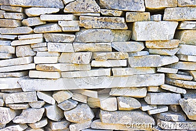 Stone wall built with blocks and marble slabs simply placed over Stock Photo