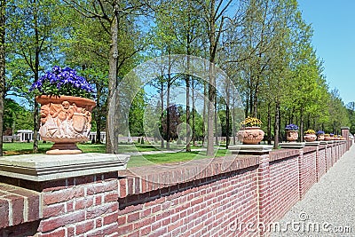 Stone wall decorated with violets filled earthenware pots Stock Photo