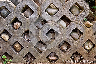 Stone wall with rocks in holes and spiderwebs - Garden Stock Photo