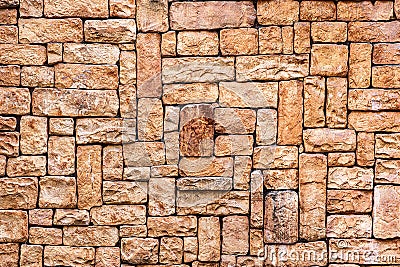 Stone wall seamless texture close-up. Bright brown rock tile texture. Tile faceted stone wall background for design. Stock Photo