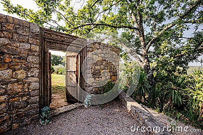 Stone wall, wooden doors opening, iron lion statues,outdoor entrance mediterranean villa Stock Photo