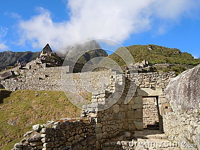 Stone walled path leading through the unique Incan designed trapezoidal doorway at Machu Picchu, Peruvian Andes, South America Stock Photo