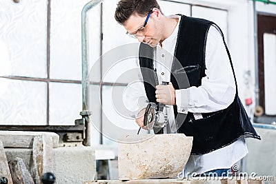 Stonemason cutting marble with angle grinder Stock Photo