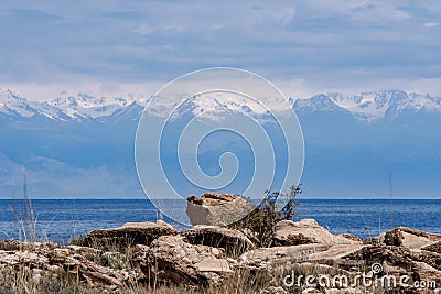 Stones on a background of lake and snow-capped mountain peaks of Stock Photo