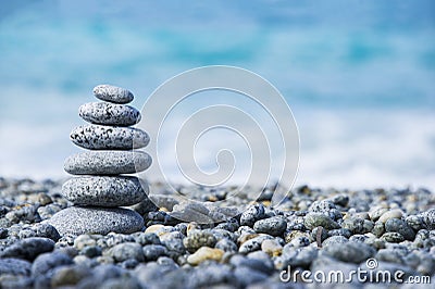 Stones pyramid on pebble beach symbolizing spa concept with blur sea background Stock Photo