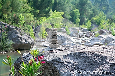 Stones pyramid on rock symbolizing stability, zen, harmony. Stock Photo