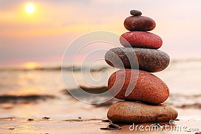 Stones pyramid on sand symbolizing harmony Stock Photo